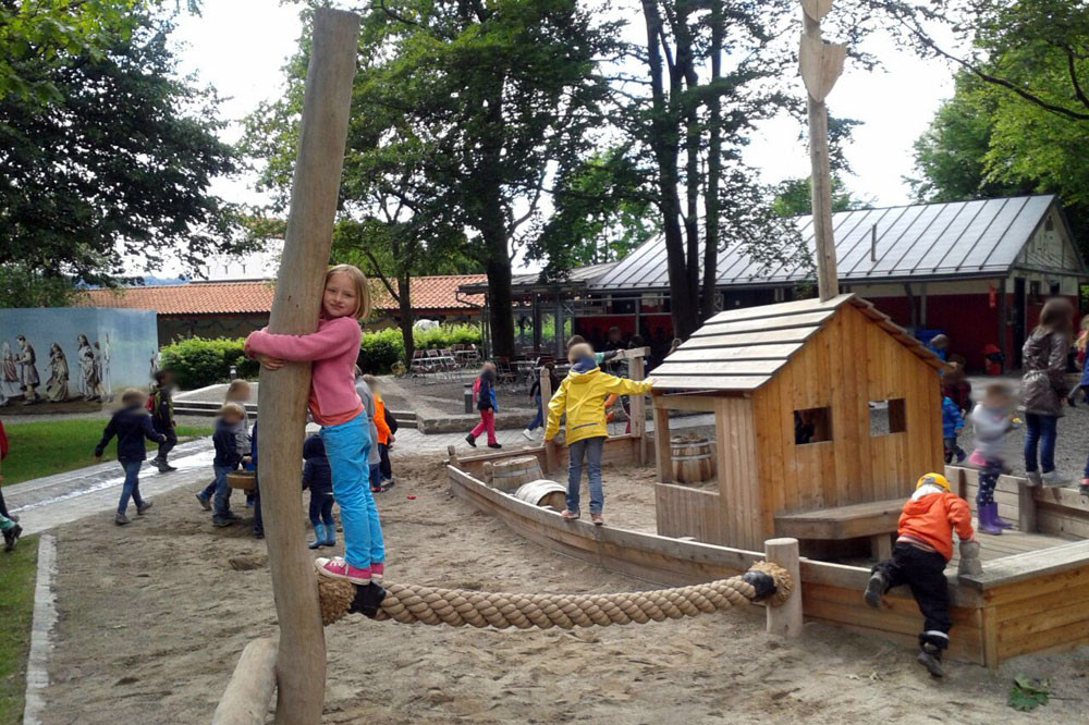 Kinder spielen auf Römerspielplatz (Bereich Sandplatz mit Holzschiff)