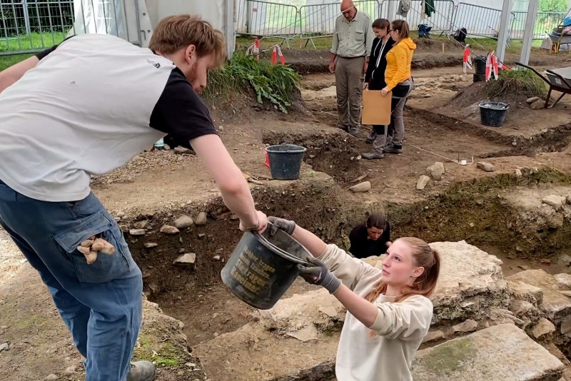 Studenten bei Grabungsarbeiten im Grabungszelt