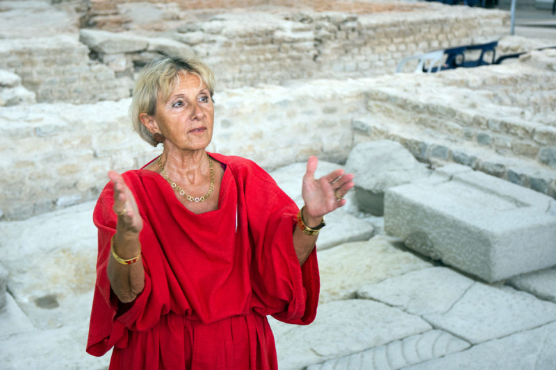 G&auml;stef&uuml;hrerin in rotem r&ouml;mischen Gewand in den Kleinen Thermen