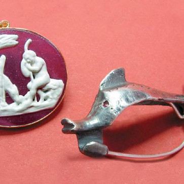 Römische Schmuck: Anstecknadel in Delfinform (Fibel) und Anhänger mit Abbildung einer Gottheit
