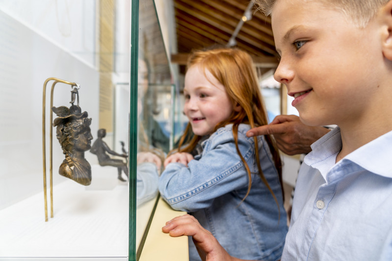 Zwei Kinder bestaunen Ausstellungsstücke in einer Vitrine