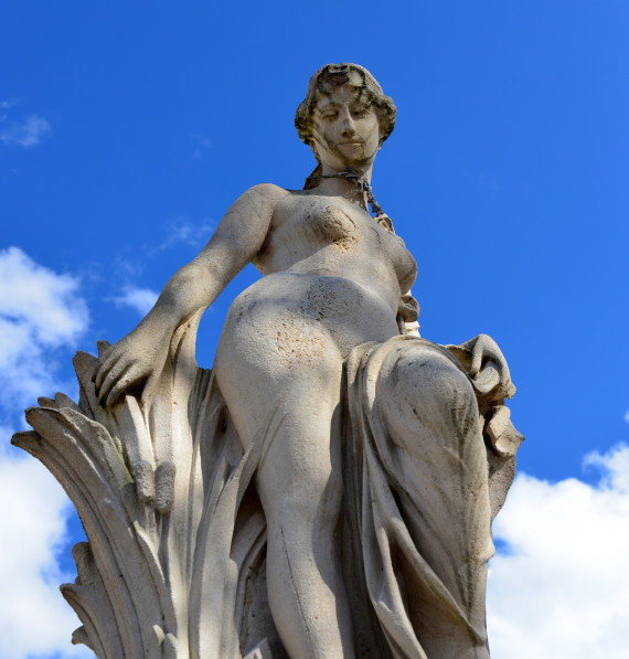 Statue einer Frau die verschmitzt nach unten blickt