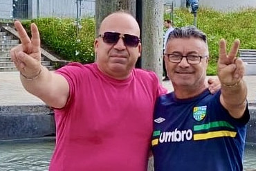 Zwei Männer machen das Victory-Zeichen