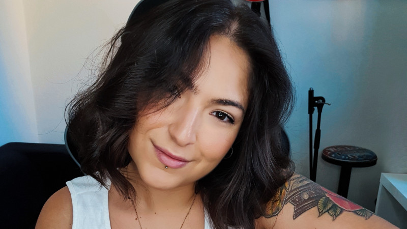 Die Sängerin, eine junge Frau, lächelt in die Kamera